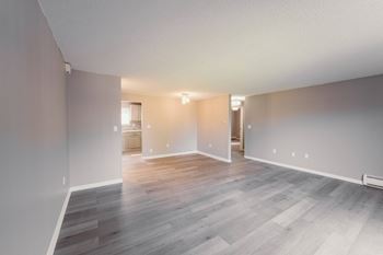a living room and dining room of an empty house with wood flooring  at BAY SHORE APARTMENTS, Connecticut, 06512